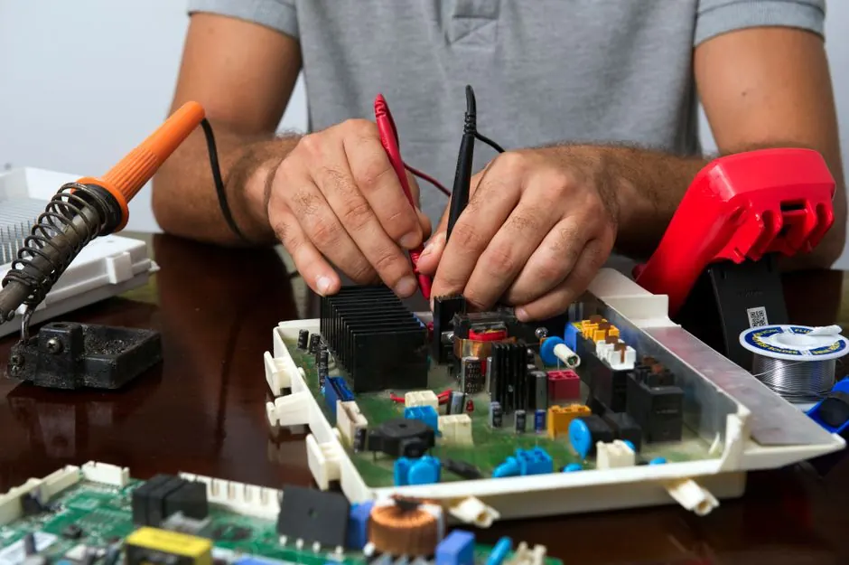 Technician skillfully repairing an electronic circuit board.